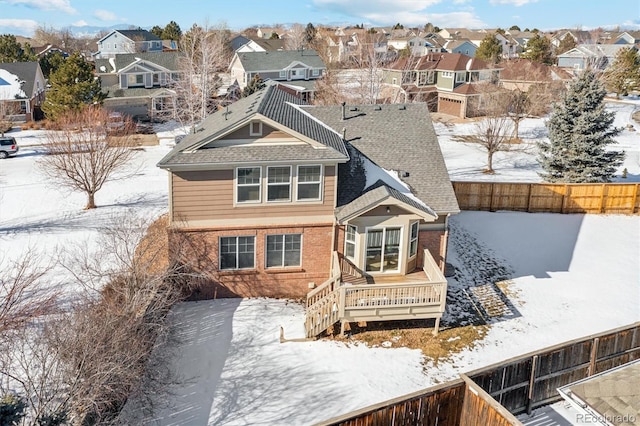 snow covered house with a deck