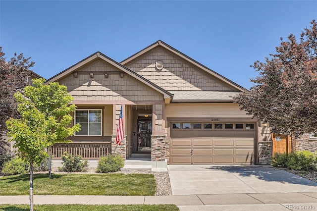 25561 E 5th Pl, Aurora, CO 80018 - view of front of property with an attached garage, concrete driveway, stone siding, a porch, and a front yard
