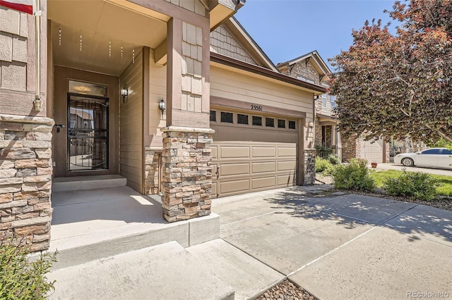 25561 E 5th Pl, Aurora, CO 80018 - property entrance with stone siding, driveway, and a garage