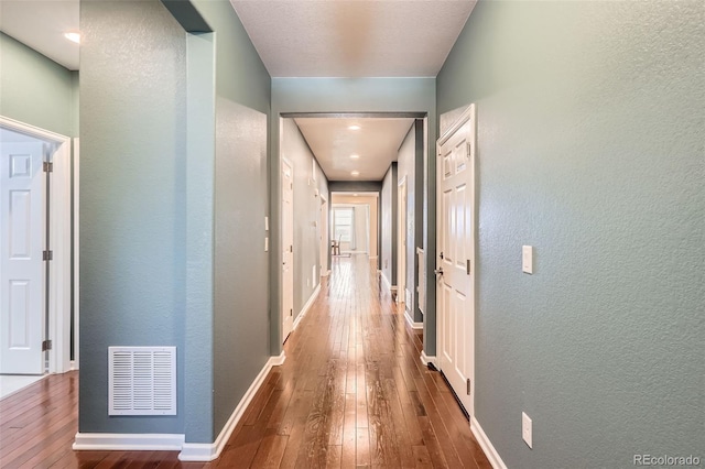 25561 E 5th Pl, Aurora, CO 80018 - corridor with hardwood / wood-style floors, a textured wall, and baseboards