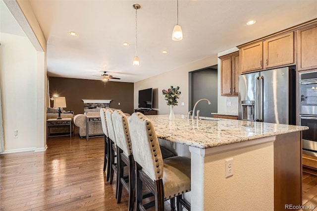 25561 E 5th Pl, Aurora, CO 80018 - kitchen featuring appliances with stainless steel finishes, a sink, ceiling fan, dark wood-style flooring, and hanging light fixtures