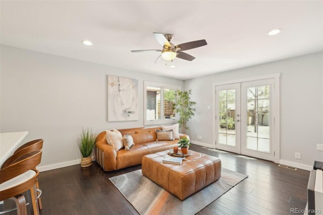 living area featuring baseboards, a ceiling fan, wood finished floors, and visible vents