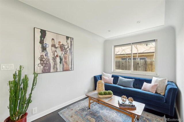 living area with baseboards and wood finished floors