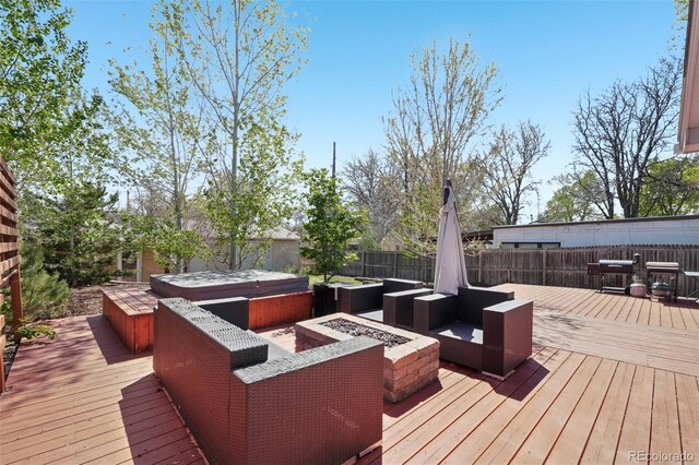 wooden deck with a fenced backyard, a covered hot tub, and an outdoor living space with a fire pit