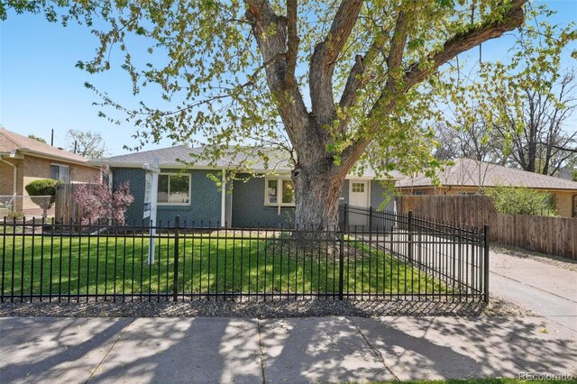 single story home with brick siding, a fenced front yard, driveway, and a front yard