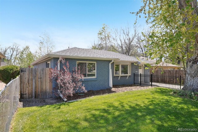 exterior space with a lawn, brick siding, a shingled roof, and a fenced backyard