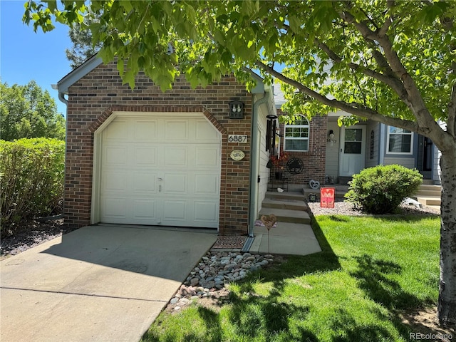 6887 S Dover Way, Littleton, CO 80128 - view of front of home featuring brick siding, an attached garage, driveway, and a front yard
