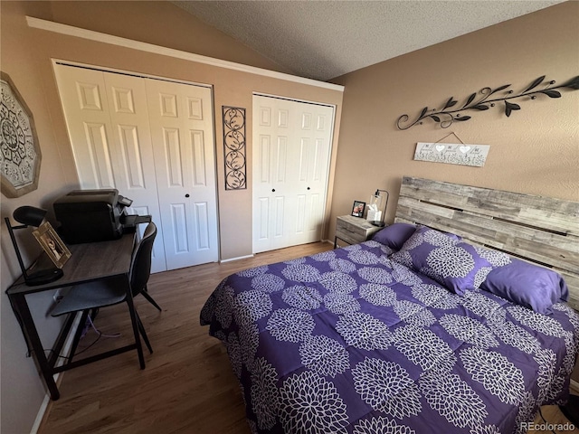 6887 S Dover Way, Littleton, CO 80128 - bedroom featuring two closets, vaulted ceiling, wood finished floors, and a textured ceiling