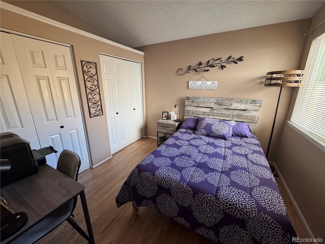 6887 S Dover Way, Littleton, CO 80128 - bedroom with multiple closets, wood finished floors, a textured ceiling, and baseboards