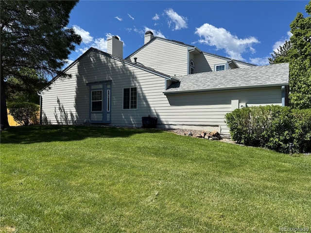 6887 S Dover Way, Littleton, CO 80128 - rear view of property with a lawn, a chimney, and a shingled roof