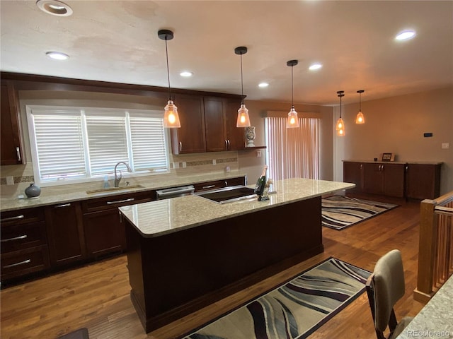 kitchen with stainless steel dishwasher, light hardwood / wood-style flooring, backsplash, and light stone counters