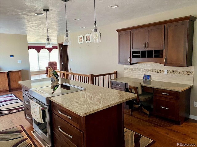 kitchen with dark hardwood / wood-style flooring, decorative backsplash, hanging light fixtures, and light stone counters