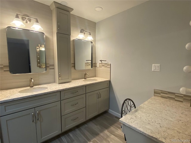 bathroom with decorative backsplash, dual vanity, and wood-type flooring