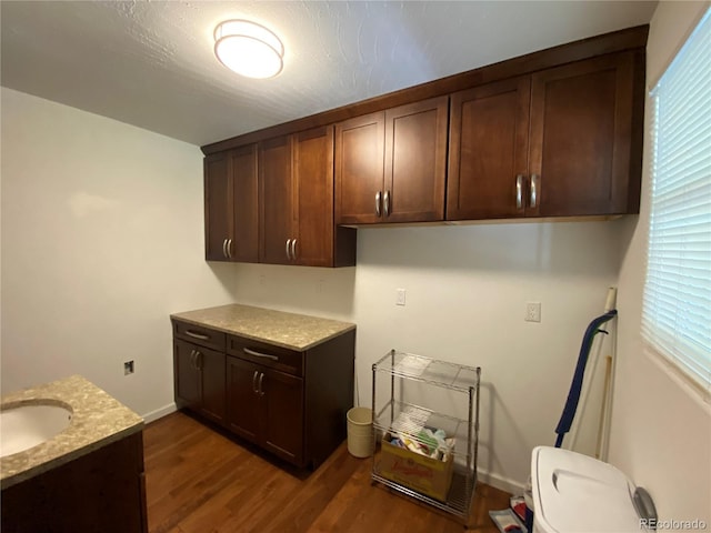 washroom featuring sink, dark hardwood / wood-style floors, and cabinets