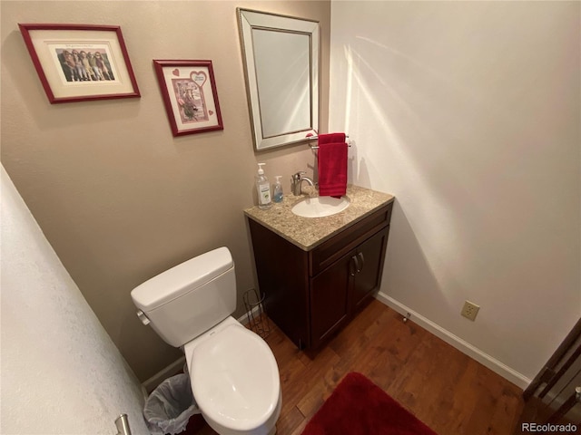 bathroom featuring toilet, vanity, and wood-type flooring