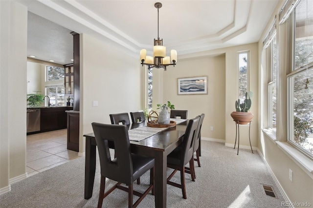 dining area featuring plenty of natural light, light colored carpet, and an inviting chandelier