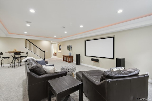 home theater with a tray ceiling and light carpet