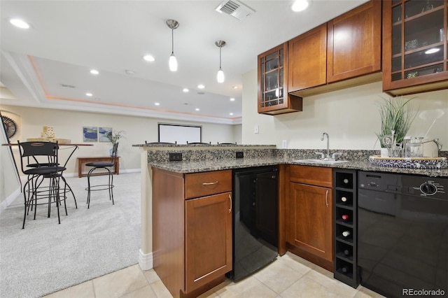 kitchen featuring pendant lighting, sink, dishwasher, light carpet, and dark stone counters