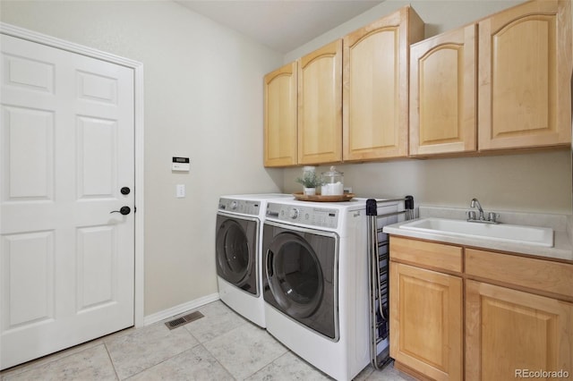 clothes washing area featuring sink, light tile patterned floors, cabinets, and washing machine and clothes dryer