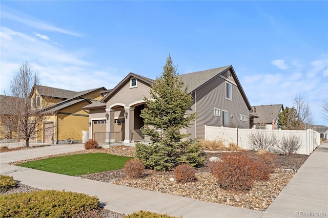 view of front of property featuring fence, a garage, driveway, and stucco siding