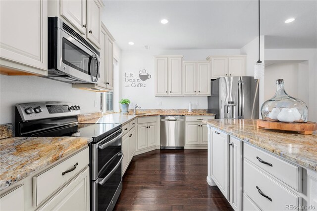 kitchen with dark wood finished floors, light stone counters, recessed lighting, stainless steel appliances, and a sink