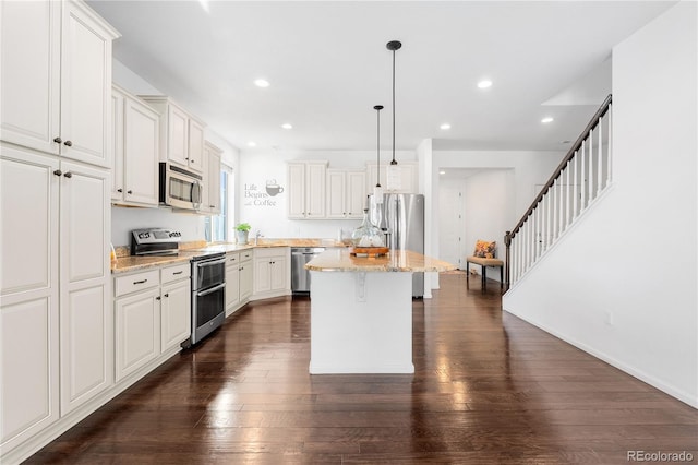 kitchen with a kitchen island, dark wood finished floors, recessed lighting, stainless steel appliances, and a breakfast bar area