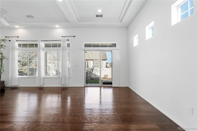 empty room with visible vents, baseboards, and wood finished floors