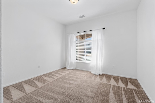 carpeted spare room featuring visible vents and baseboards