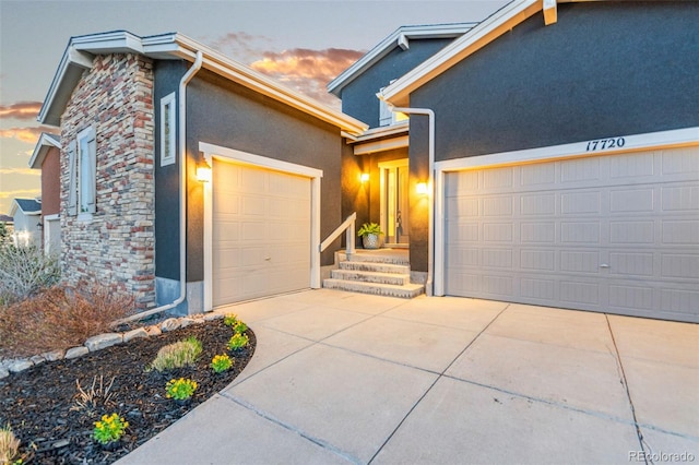 17720 W 94th Dr, Arvada, CO 80007 - view of front of house with stone siding, stucco siding, concrete driveway, and an attached garage