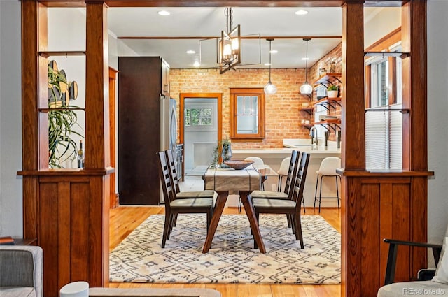 3928 Zuni St, Denver, CO 80211 - dining area featuring wood finished floors, recessed lighting, and brick wall