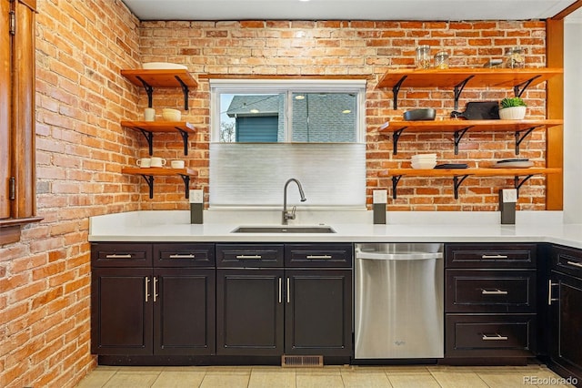 3928 Zuni St, Denver, CO 80211 - kitchen featuring open shelves, stainless steel dishwasher, a sink, brick wall, and light tile patterned flooring