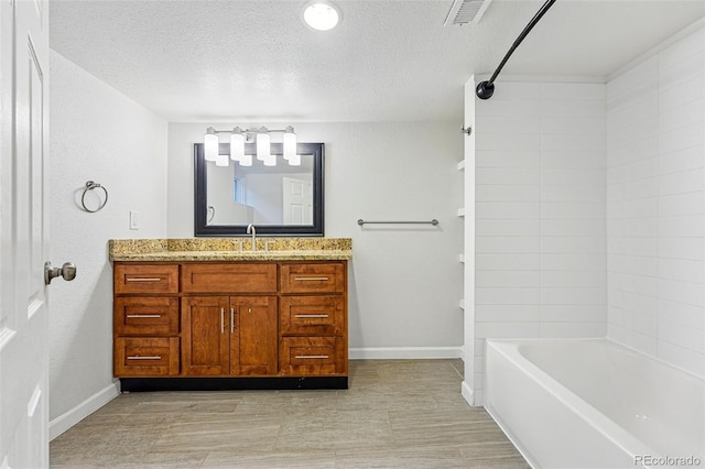 3928 Zuni St, Denver, CO 80211 - bathroom with baseboards, vanity,  shower combination, and a textured ceiling