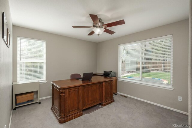 office area featuring a ceiling fan, baseboards, and light carpet