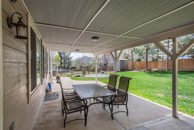 view of patio / terrace with a shed, an outbuilding, outdoor dining area, and a mountain view