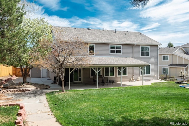 back of property with a patio area and roof with shingles