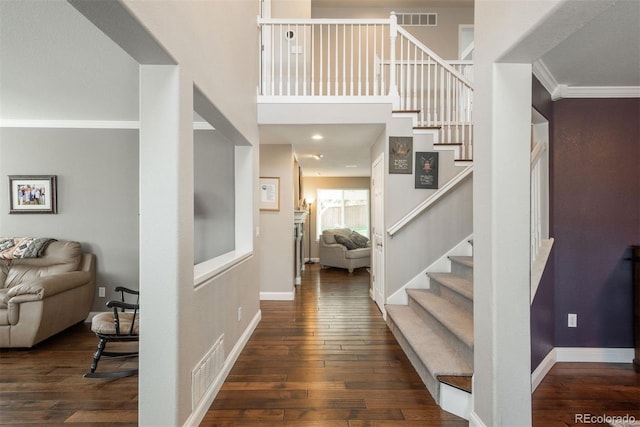foyer entrance featuring stairs, hardwood / wood-style flooring, baseboards, and crown molding