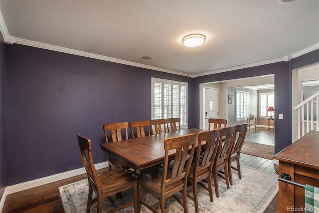 dining room with hardwood / wood-style floors, crown molding, and baseboards