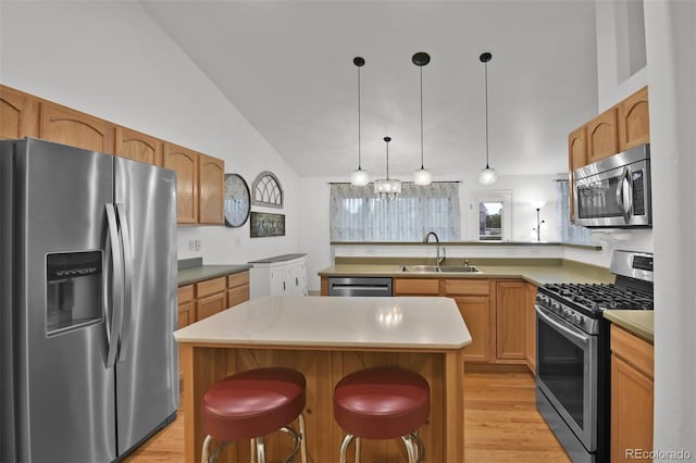 12454 Tex Tan Rd, Peyton, CO 80831 - kitchen featuring stainless steel appliances, a sink, light wood-style flooring, a peninsula, and decorative light fixtures