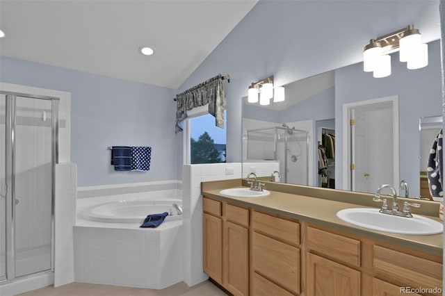 12454 Tex Tan Rd, Peyton, CO 80831 - bathroom with vaulted ceiling, a spacious closet, a stall shower, a bath, and double vanity