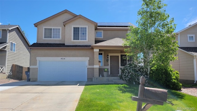 4214 Widener St, Pueblo, CO 81008 - view of front facade with stucco siding, roof mounted solar panels, an attached garage, and concrete driveway