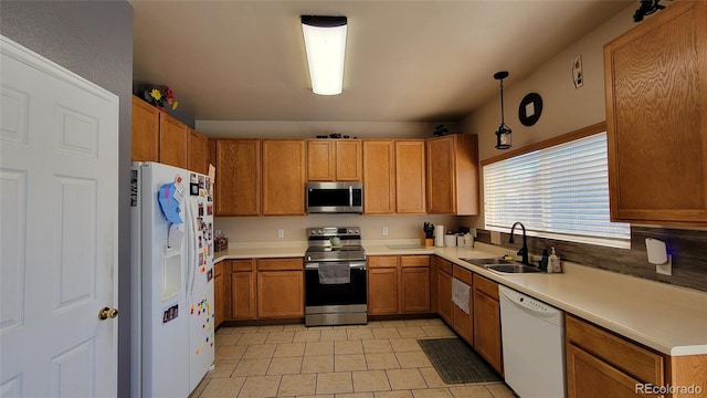 4214 Widener St, Pueblo, CO 81008 - kitchen featuring appliances with stainless steel finishes, a sink, light countertops, light tile patterned flooring, and brown cabinetry