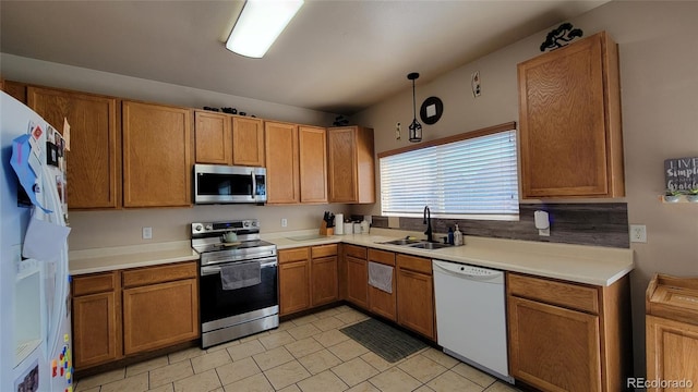 4214 Widener St, Pueblo, CO 81008 - kitchen with stainless steel appliances, a sink, light tile patterned flooring, light countertops, and brown cabinets