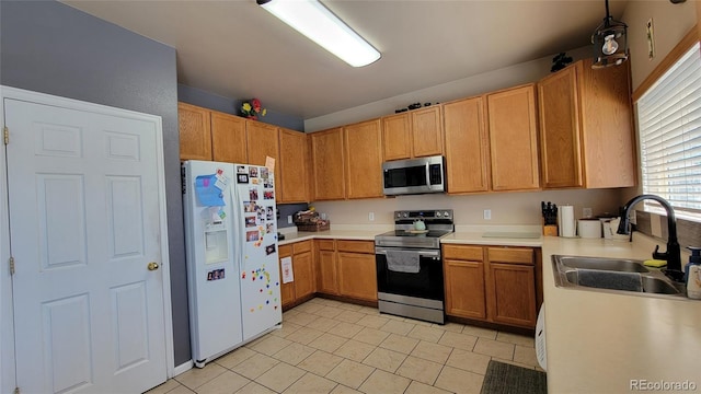 4214 Widener St, Pueblo, CO 81008 - kitchen featuring appliances with stainless steel finishes, light tile patterned floors, light countertops, and a sink