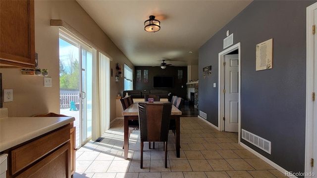 4214 Widener St, Pueblo, CO 81008 - dining room featuring ceiling fan, light tile patterned flooring, and a fireplace