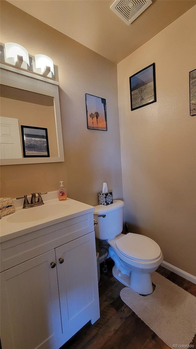 4214 Widener St, Pueblo, CO 81008 - bathroom with wood finished floors, toilet, vanity, and baseboards