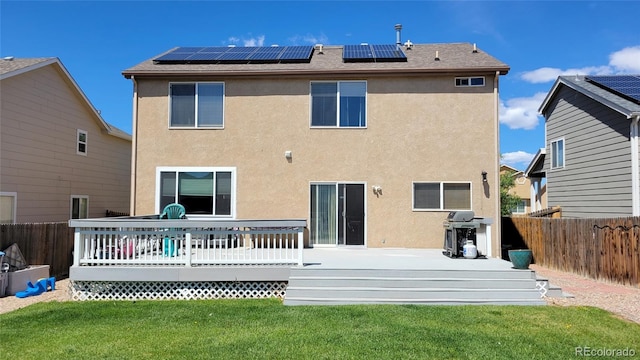 4214 Widener St, Pueblo, CO 81008 - rear view of house featuring stucco siding, roof mounted solar panels, and a deck