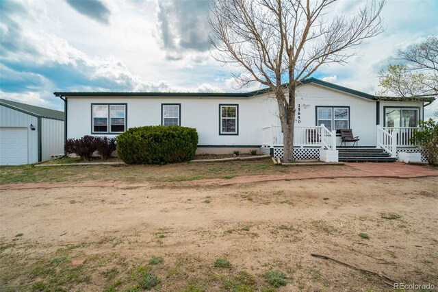 15650 W Valdez Cir, Peyton, CO 80831 - view of front of property with an outdoor structure, a wooden deck, and a garage