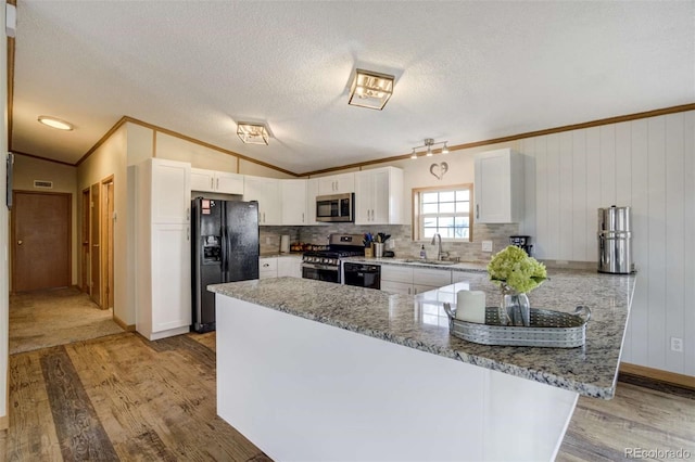 15650 W Valdez Cir, Peyton, CO 80831 - kitchen with black appliances, a sink, light wood-style flooring, ornamental molding, and white cabinets