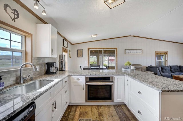 15650 W Valdez Cir, Peyton, CO 80831 - kitchen featuring stainless steel oven, a sink, wood finished floors, lofted ceiling, and black dishwasher