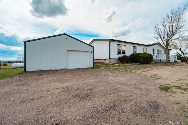 15650 W Valdez Cir, Peyton, CO 80831 - view of front of property with dirt driveway, a garage, an outbuilding, and crawl space
